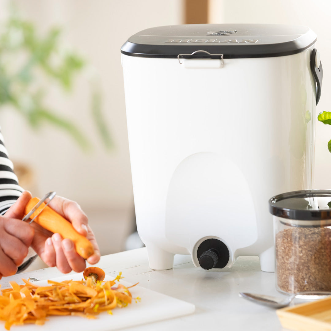 Person using a vegetable peeler with a white food chopper in the background